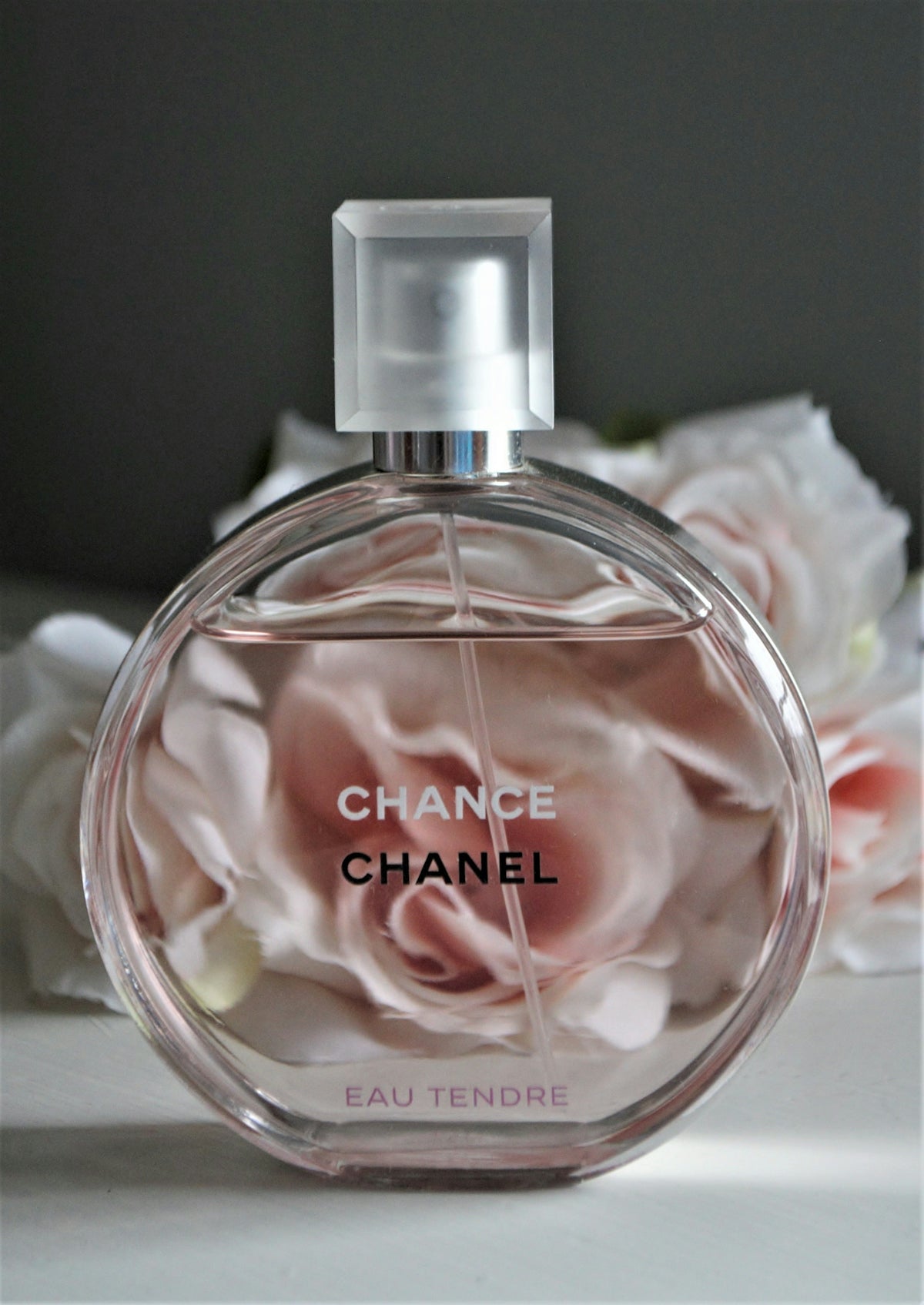 Clear glass perfume bottle with pink liquid