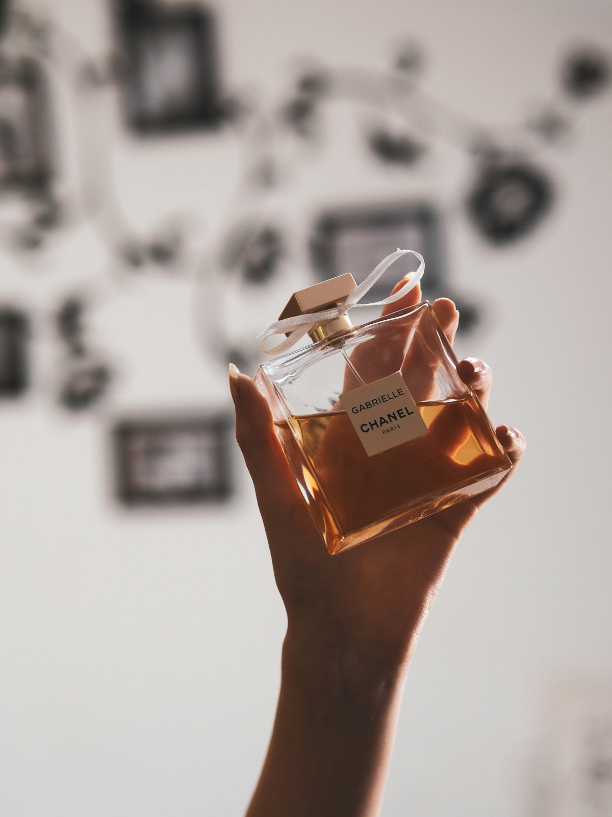 Person holding clear glass perfume bottle