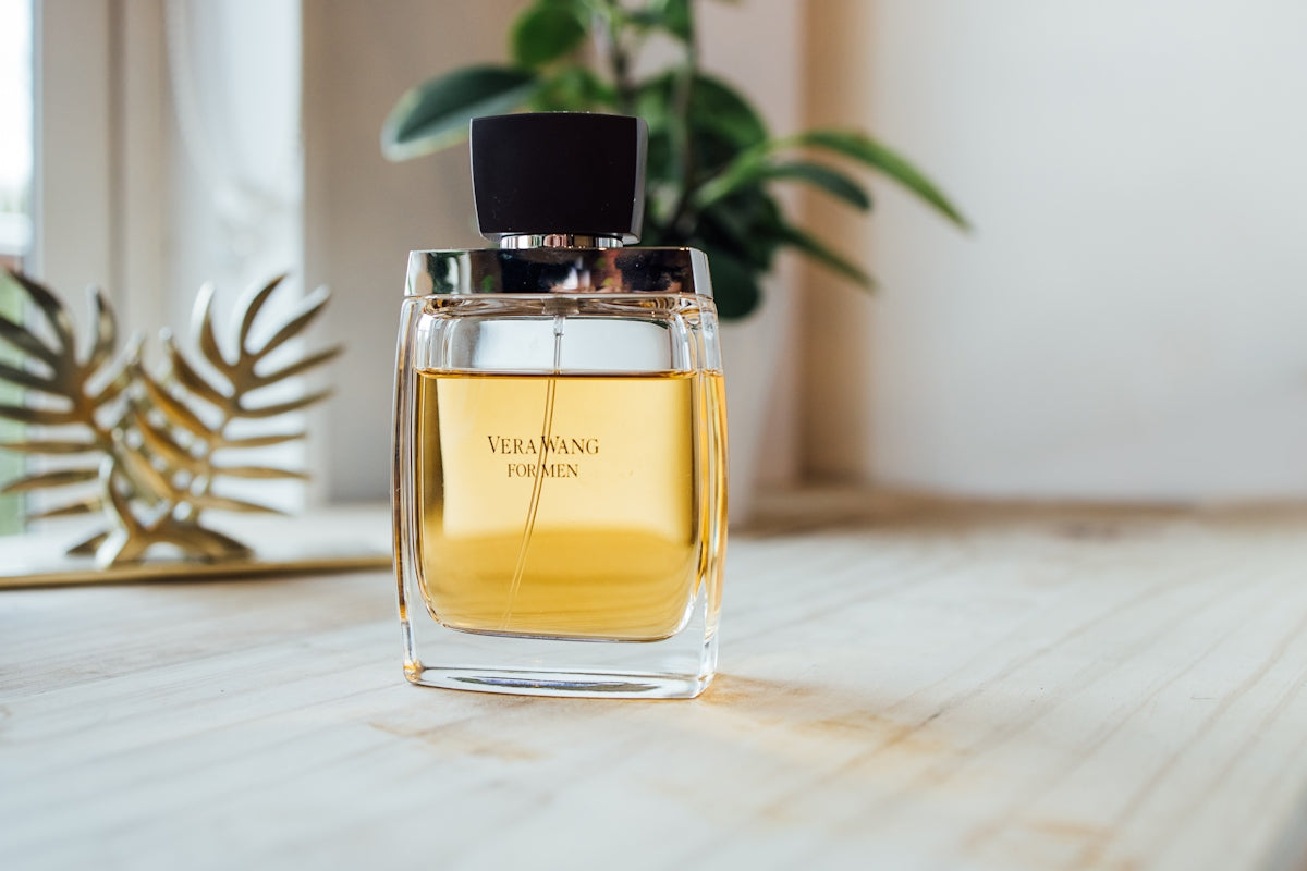 Clear glass perfume bottle on brown wooden table