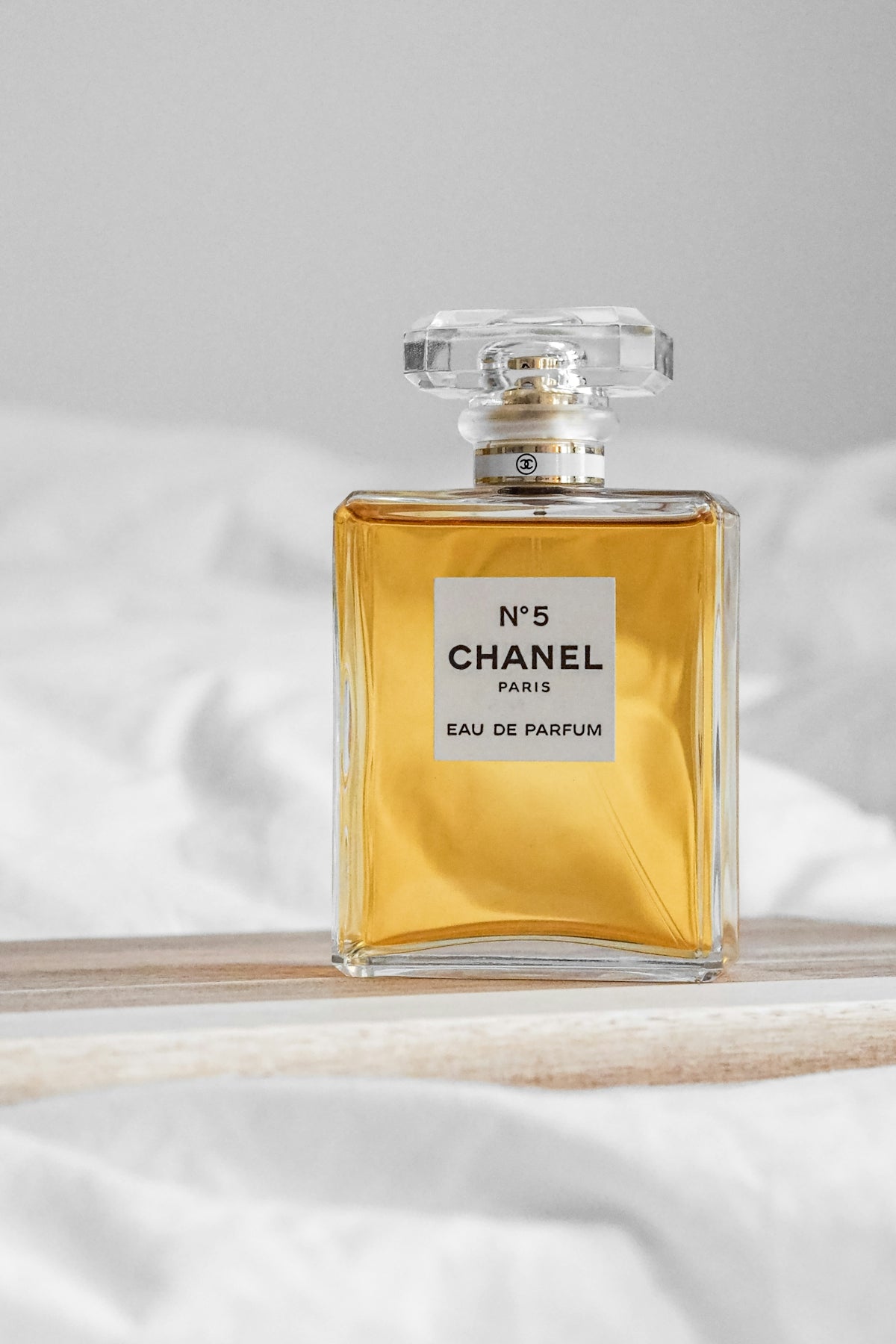 A bottle of perfume sitting on top of a bed
