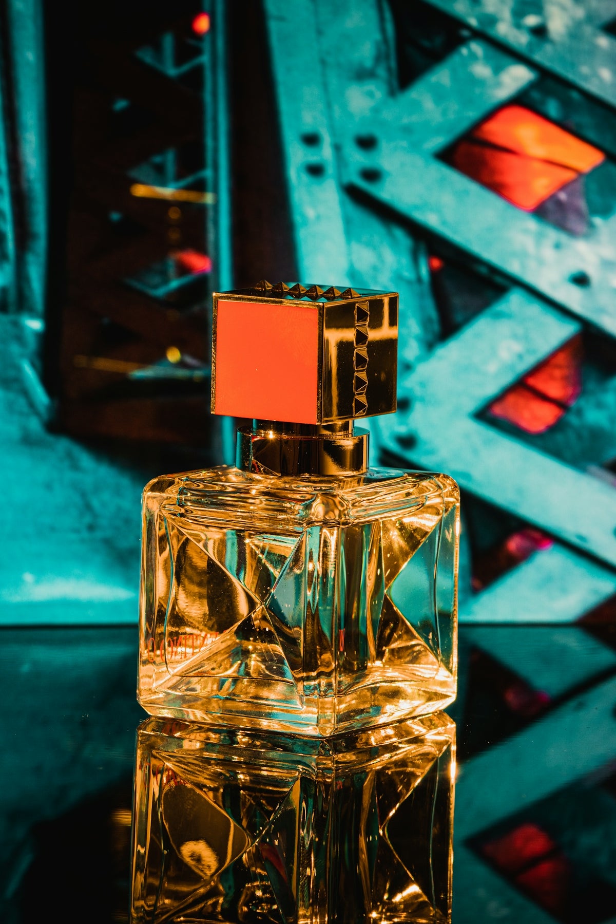 Clear glass perfume bottle on blue surface