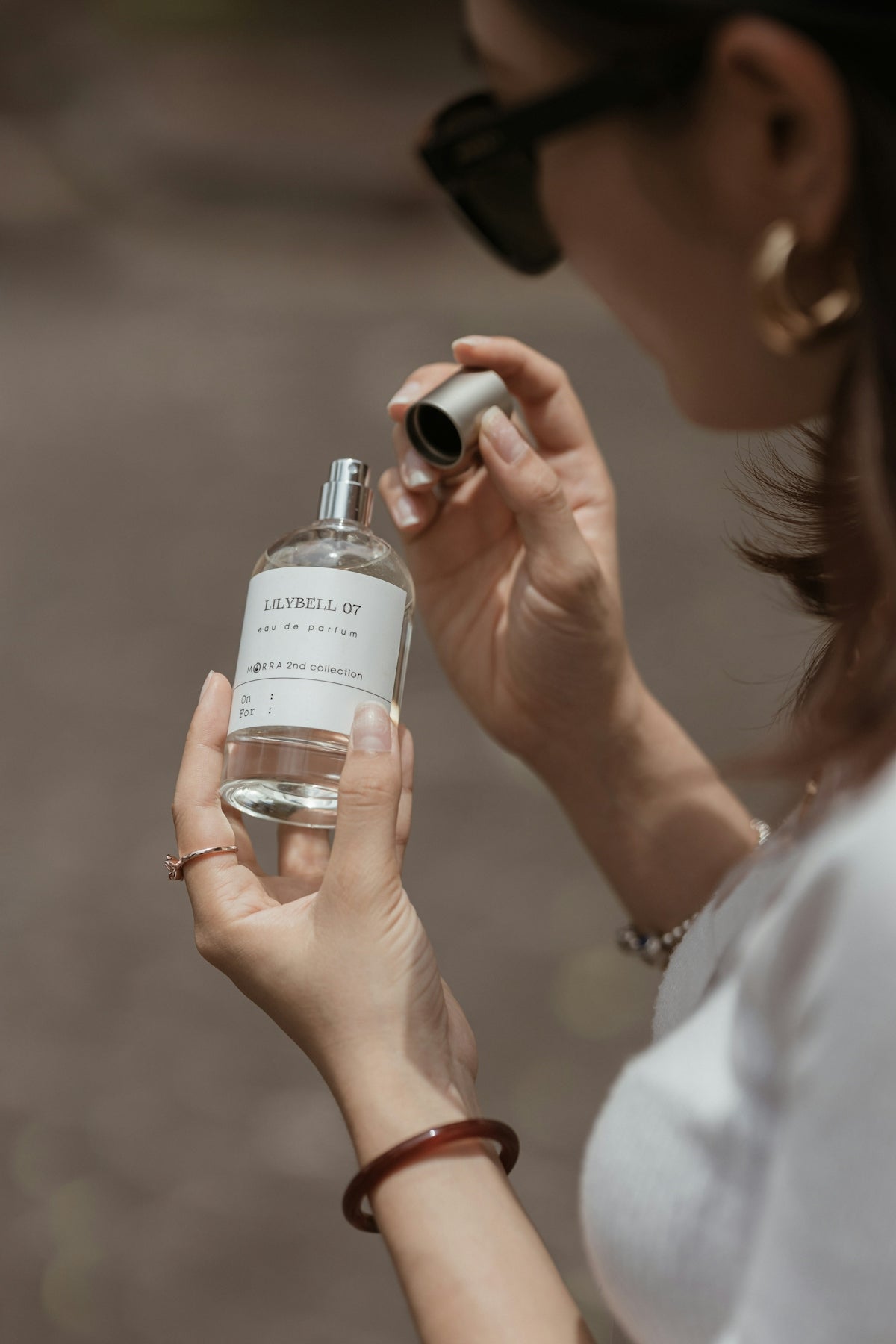 A woman holding a bottle of perfume in her hand