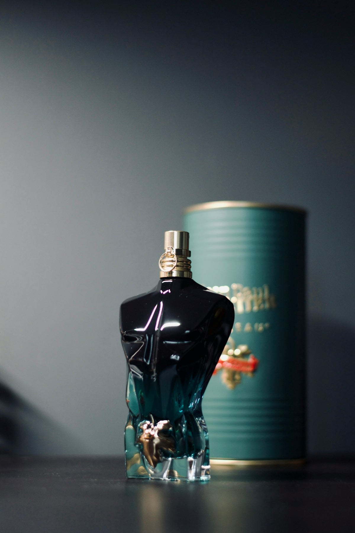 A bottle of perfume sitting next to a can