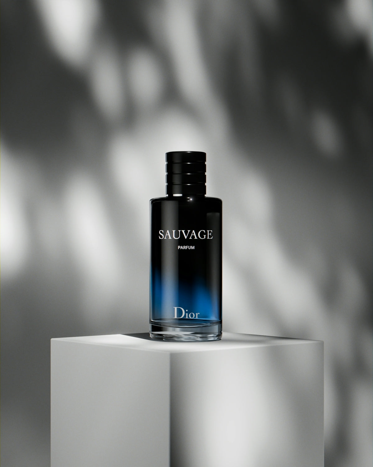 A bottle of cologne sitting on top of a white block
