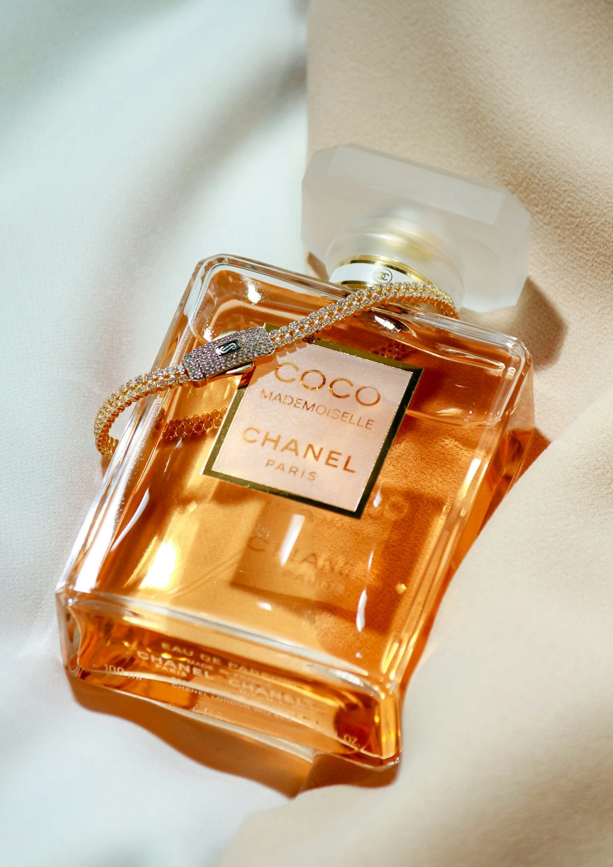 A bottle of perfume sitting on top of a bed