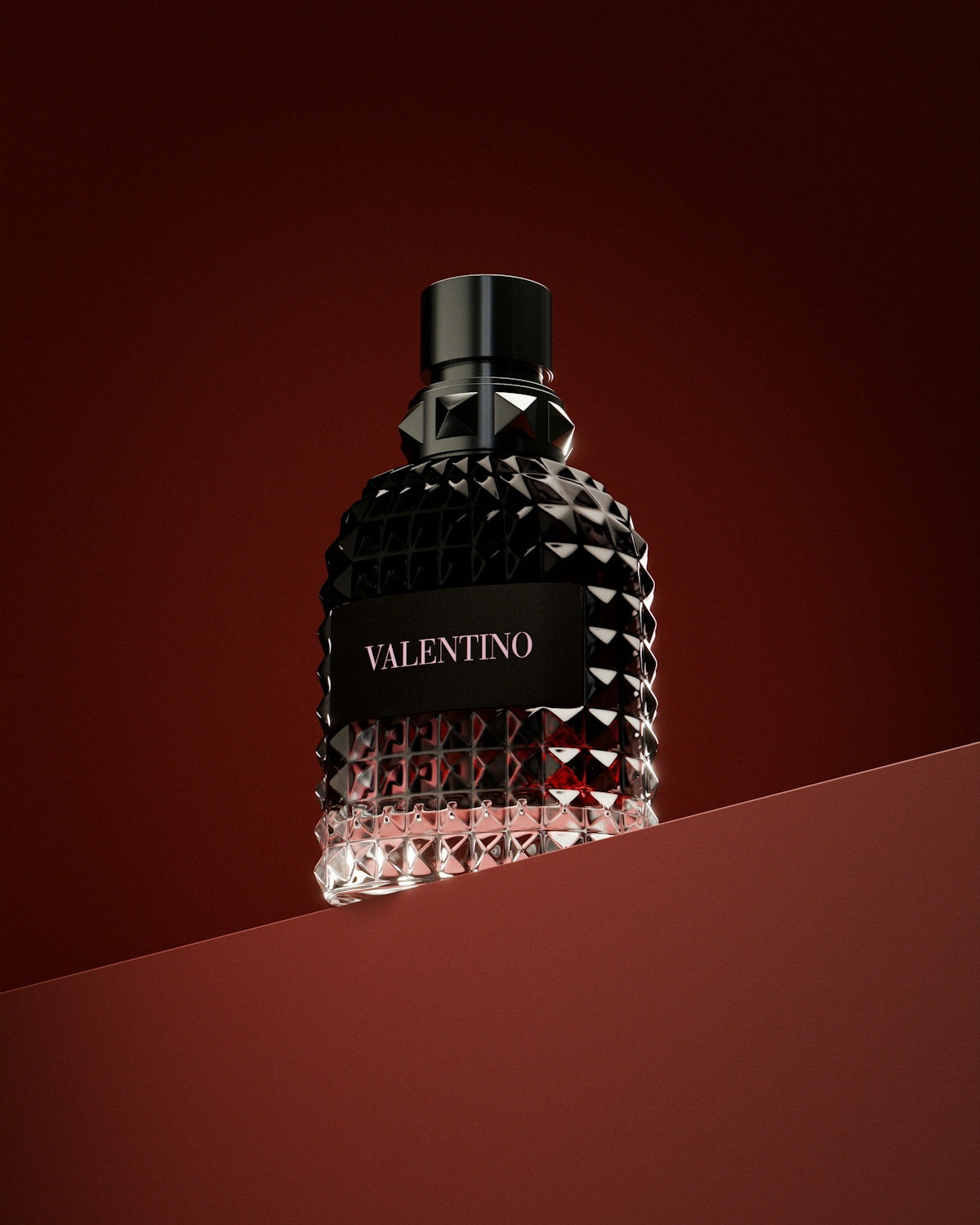 A bottle of perfume sitting on top of a red surface