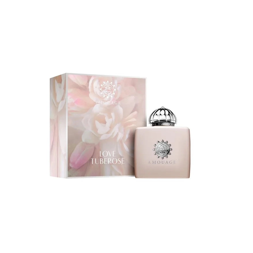 Amouragi Love Tuberosa perfume bottle in a pale pink shade with a silver cap, displayed next to its matching floral-patterned packaging box on a white background.